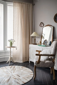 Detailed view of beige cotton linen kitchen curtain with daisy floral prints and tassels