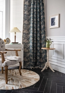 Detail of blue floral curtain fabric with thick texture and decorative fringe tassel edge