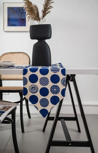 Close-up of blue and white geometric table runner with artistic circular patterns and tassels