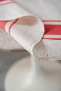 Makro-Detail roter Streifen auf beigem Leinentischtuch mit hochwertigem Saumrand