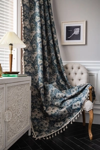 Detail of blue floral curtain with vintage oil painting style and white fringe trim