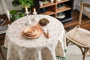 Close-up of floral cotton linen tablecloth with elegant green tassel edge details