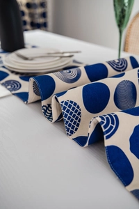 Detail of blue and white geometric table runner with circles on a white dining table