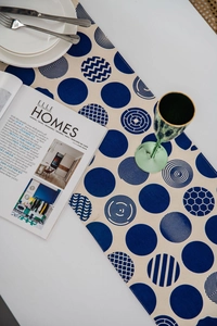 Detail of Nordic style table runner with blue geometric circles on beige linen fabric