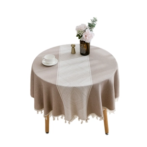 Elegant beige round tablecloth with geometric diamond pattern and fringe tassels for dining table