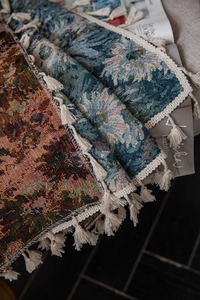 Detail showing woven retro floral tapestries with fringe edges in red and blue tones