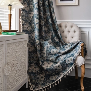 Blue oil painting floral curtain with white fringe tassels in a rustic vintage room