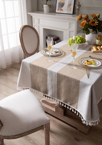 Detail of faux linen tablecloth with white lace stitching and decorative tassel edges