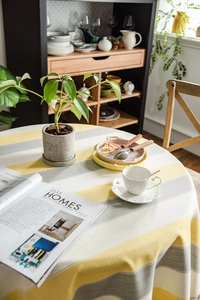 Macro view of yellow striped linen-textured tablecloth with elegant fringe detail