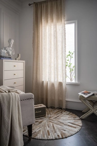 Detail showing natural linen blend texture and delicate tassel trim of the sheer curtain