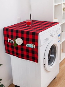 Detail of red and black plaid washing machine cover with side pockets and white pompoms