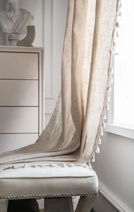 Close-up of oatmeal linen texture curtain featuring decorative white tassel edges