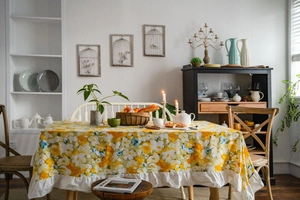 Detailed view of yellow floral pattern and elegant ruffled edge on pastoral tablecloth