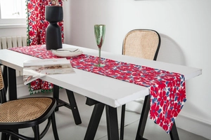 Detail of red floral Chinese table runner on a dining table with matching curtains