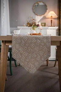Close-up of oatmeal fabric table runner with white daisy print and V-shaped pointed end