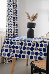Detailed close-up of modern navy blue dot patterns on beige linen tablecloth and curtains