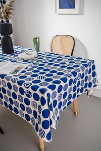 Detail of blue geometric polka dots on cream linen tablecloth in a modern Nordic setting