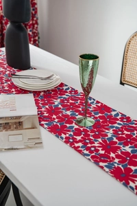 Detailed texture of red floral print table runner on dining table in modern setting