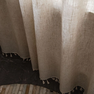 Neutral beige linen textured curtain with fringe trim and natural drape for home decor