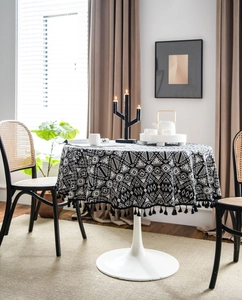 Detail of black and white geometric round tablecloth with elegant black fringe tassels