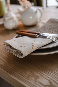 Detailed texture of cotton linen table runner with white daisy floral embroidery pattern