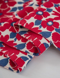 Close-up of red flower print on cream linen table runner with detailed stitching