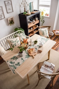 Detail of pine cone print table runner and matching pillow covers in linen fabric