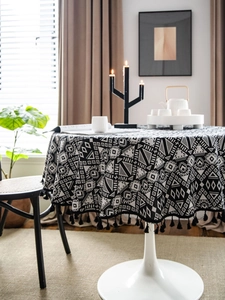 Close-up of black and white geometric round tablecloth with elegant tassel fringe edge