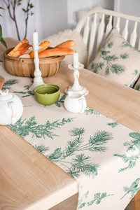 Detail of pine cone print table runner with matching cushions on a wooden table