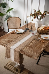 Close-up of rustic woven table runner featuring brown stripes and decorative tassels
