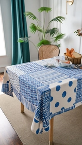Detailed close-up of blue geometric patchwork linen tablecloth with elegant draping