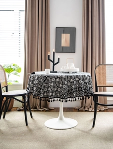 Detail of bohemian geometric pattern tablecloth with elegant black decorative fringe tassels