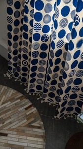 Detail of blue geometric dots pattern and fringe trim on bohemian linen blend curtains