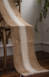 Detail of woven table runner with cotton linen texture and delicate tassel fringe