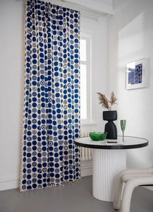 Detailed close-up of blue polka dots with geometric patterns and beige fringe tassels