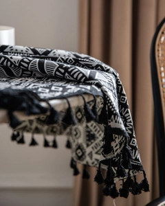 Detail of Nordic black and white geometric woven tablecloth with thick black fringe tassels