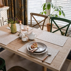 Floral table runner set with white blossoms and orange dots on beige fabric