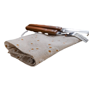 Beige floral table runner with white daisy patterns and rustic wooden cutlery