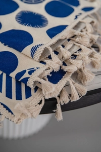 Close-up of bohemian blue dot printed fabric with woven fringe details and texture