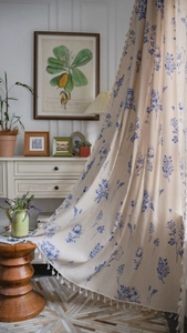 Detail of blue floral print curtains with tassel fringe in French vintage cotton linen