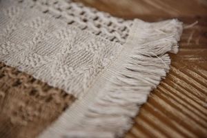 Close-up of woven table runner showing cotton linen textures and knotted fringe details