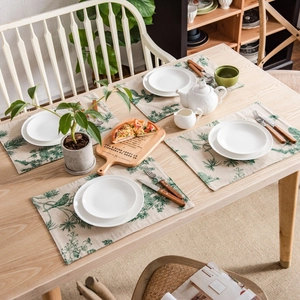 Green pine cone print table runner set in Nordic style on light wood dining table