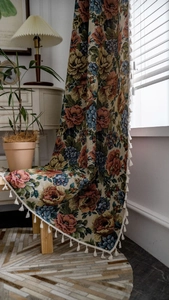 Detail von Vintage-Rosen-Jacquard-Stoff mit weißen Baumwollfransen auf Holzstuhl