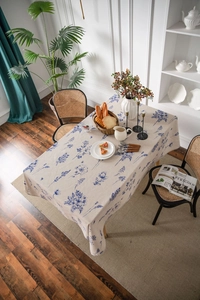 Close-up of linen tablecloth featuring blue floral patterns and natural texture drape