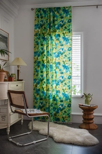 Détail d'un rideau bohème tie-dye vert avec imprimé fleuri et franges à pompons