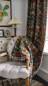 Detail eines Vintage-Jacquard-Vorhangs mit rosa Rosenmustern und weißen Fransen