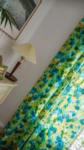 Détail d'un rideau bohème vert tie-dye avec franges à glands blancs et texture du tissu