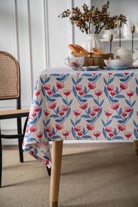Detail of pink tulip floral print on cream linen tablecloth with soft natural lighting