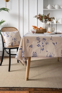 Detailed view of linen tablecloth with blue floral prints and matching cushions