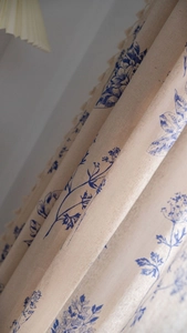 Detailed view of vintage blue floral patterns on linen fabric with elegant natural drapes